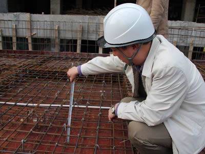 Workers are checking the thickness of constructional reinforcement.